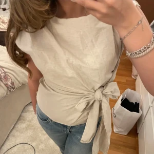 Beige omlottopp  - söt topp i linne-liknande material. tror storlek S eller möjligtvis M men går att justera i midjan. köp flera plagg i bundles för ett billigare pris!❤️