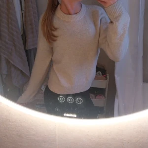 Beige stickad tröja - Supermjuk och mysig beige stickad tröja med rund halsringning och ribbade muddar vid ärmslut och nederkant. Perfekt för lager-på-lager och chill dagar. Långärmad och i en klassisk, enkel modell som passar till allt.