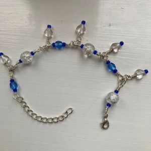 Armband - Unikt armband med silverfärgad kedja och mix av blå och klara pärlor i olika former. Justerbar längd med karbinhake. Perfekt för dig som gillar färg och detaljer! Jag har gjort den själv. Skriv gärna om du vill specialbeställa ett armband!💕