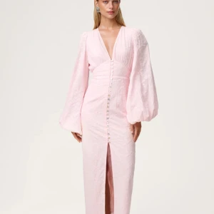 Ljusrosa långklänning med puffärm - Superfin ljusrosa långklänning med broderade blommor, djup v-ringning och puffiga långärmar. Klänningen har knappar framtill och en slits nedtill. Perfekt för sommarens speciella tillfällen! Använd en gång!!