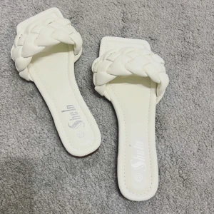 Vita flätade sandaler från Shein - Snygga vita sandaler från Shein med bred, flätad rem över foten och fyrkantig tå. INTE ANVÄNDA- men de är väldigt fina!