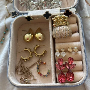 Mix av trendiga smycken i guld och silver - Samling med örhängen, armband, halsband och ringar i guld och silver. Inkluderar chunky guldörhängen, örhängen med rosa stenar, stora silvriga blomörhängen, armband med knut och stenar, halsband med turkosa pärlor och färgglad C-berlock. Perfekt för dig som gillar att mixa stilar och färger. En massa massa fina unika smycken som tyvärr inte längre kommer till användning då jag bytt till silver. Skriv privat för enskilda smycken och priser osv💕