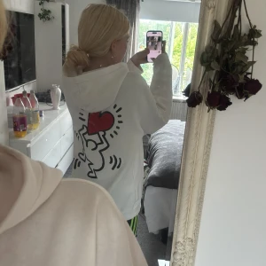 Vit hoodie med Keith Haring-tryck H&M - Säljer en vit hoodie från H&M med Keith Haring-inspirerat tryck på ryggen och texten 'LOVE' med hjärta framtill. Hoodien har huva och relaxed fit. 💘