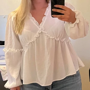 Vit blus med volanger - En superfin blus i storlek M som är perfekt till sommarkvällar. Endast använd ett fåtal gånger☺️