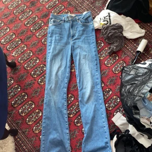  ljusblå bootcut jeans - Säljer ett par jeans i storlek S! De har bootcut passform, hög midja och raka ben som slutar i en lätt utsvängning. Töjbart material! Står inte vart den kommer ifrån men har för mig att jag köpte den på Gina tricot men kan ha fel. Pris kan diskuteras! 