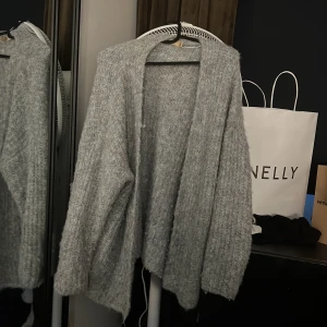 Grå stickad kofta från Culture  - grå kofta från Culture i stickat material. Koftan har lång ärm, öppen framtill och en fluffig, mjuk känsla, andvänd 1-2 gånger