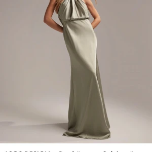 Grön axelbandslös långklänning - Elegant grön långklänning med axelbandslös design och draperad detalj framtill. Perfekt för en stilfull kväll. Aldrig använd med prislapp kvar storlek M