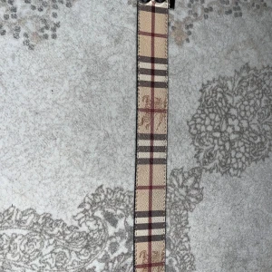 Tre stiliga bälten med rutigt mönster - Säljer tre bälten med olika rutiga mönster. Ett i beige och röd, ett i svart och grå, och ett i brun och svart. Alla har unika spännen som ger en lyxig känsla. Perfekta för att lyfta vilken outfit som helst!