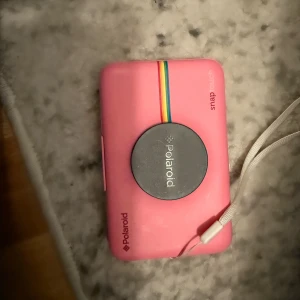 Polaroid SNAP Touch 2.0 kamera  - Selling a Polaroid SNAP Touch 2.0 – a portable 13MP digital instant camera with an LCD touchscreen and Zink Zero Ink technology for printing 2x3 inch photos instantly. Original price for the pink edition: approximately 320 euros. Asking price: make an offer!   It comes in a rare pink color, making it a unique find for instant photography lovers!  NOTE: The outer metal frame is damaged - therefore the camera is not working, but the camera itself may still be repairable or useful for spare parts. 