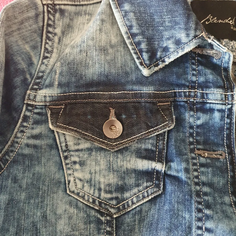Snygg blå jeansjacka från BlendShe med klassisk krage och knappar framtill. Jackan har två bröstfickor med knapp och två sidofickor med dragkedja. Perfekt för en avslappnad stil. Storlek 36/S. Helt oanvänd, men jag hann klippa bort lappen. Bakstycke 46 cm.. Takit.
