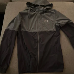 Under Armour windbreaker - Säljer en stilren grå windbreaker från Under Armour. Inga defekter använd bara ett par gånger