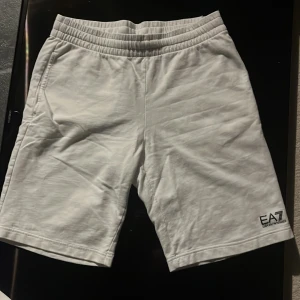 Vita shorts från Emporio Armani - Snygga vita shorts från Emporio Armani med elastisk midja och EA7-logga. Perfekta för en stilren look. Tillverkade i mjukt material för extra komfort.