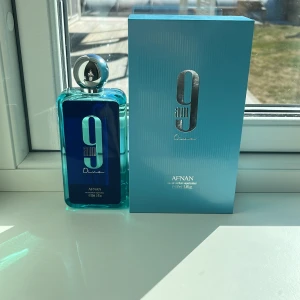 Afnan 9am Dive Parfym - Fräsch och uppfriskande parfym från Afnan, 9am Dive, i en stilren blå flaska med silverdetaljer. Flaskan har en rund metallkork och kommer i en matchande blå förpackning med havsinspirerat mönster inuti. Perfekt för den som söker en modern och energisk doft.