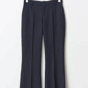 Marinblåa kostymbyxor med vita ränder - Snygga marinblå kostymbyxor med vita ränder. Byxorna är utsvängda och är perfekta för en stilren look. De har en låg midja och är tillverkade i ett bekvämt material.