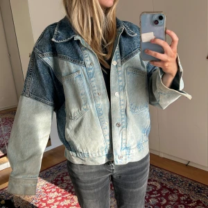 Tvåfärgad jeansjacka - Säljer en cool tvåfärgad jeansjacka från Mango. Jackan har stora ute fickor samt gömda stora innerfickor. 