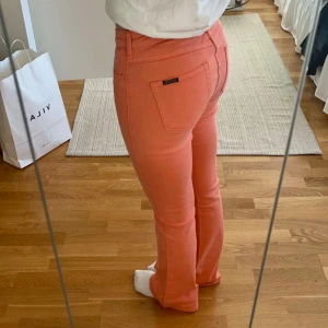Korallfärgade jeansbyxor - Snygga korallfärgade jeans med en bootcut passform och låg midja. Super fina nu till sommaren. Storlek 26🎀 