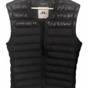 J Lindeberg dunväst - J Lindeberg dunväst | Västen är i nyskick | endast använd ett fåtal gånger | Västen är storlek L men Passar M | Nypris ligger på 1800kr | västen är köpt på j Lindeberg mall of scandinavia | Hör av dig vid frågor eller prisförslag|