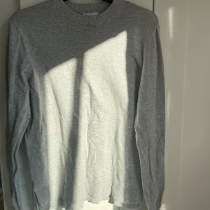 Grå tröja från H&M!!! - Säljer en stilren grå tröja från H&M Basics. Tröjan har en klassisk rund hals och långa ärmar, perfekt för en enkel och bekväm look. Passar bra till allt💕