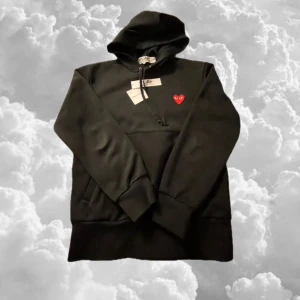 Svart hoodie med rött hjärta från Comme des Garçons - Säljer en stilren svart hoodie från Comme des Garçons med ett rött hjärta på bröstet. Tröjan är i 8/10 skick (sparsamt använd), storlek S men sitter mer åt XS hållet 🔥😎(modellen är 172,59kg )