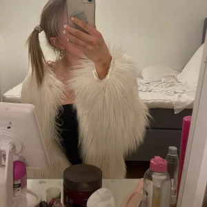Vit pälsjacka - Säljer en fluffig vit pälsjacka med långa ärmar. Perfekt för att hålla sig varm och stilren under kyliga dagar. Jackan har en elegant look och passar bra till olika outfits.