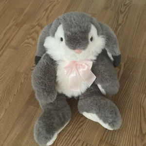 Gosedjur - Ett gosedjur i form av en kanin med en rosa rosett. 