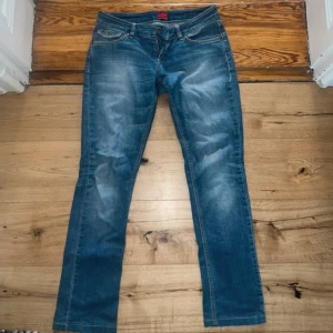 Blå jeans från Vero Moda W28 L34 - Snygga blå jeans från Vero Moda med klassisk femficksdesign och coola detaljer på bakfickorna. Jeansen har normal passform och raka ben, tillverkade i slitstarkt denim. Perfekta för dig som gillar en tidlös och avslappnad look.