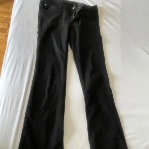 Low waist cheap monday jeans - Säljer ett par svarta bootcut jeans från Cheap Monday med klassisk femficksdesign och dragkedja. Jeansen har en snygg passform med utsvängda ben och low waist. Byxorna är inte kol svarta utan har tappat lite färg. 32/32 byxorna är väl lite nedtrampade där nere