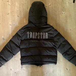 Trapstar Decoded Puffer 2.0 - Väl använd Trapstar jacka i fint skick. Lite slitage på materialet på höger arm samt på bröstet men det syns knappt. Kan nog hjälpa att tvätta den också. Lite slitage på insidan vid waistband. Överlag välbehållen. Pm så kan jag skicka fler bilder.