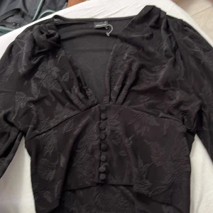 Svart långärmad tröja med knappar - Tröja från ginatricot 