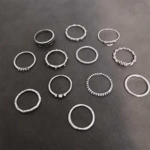 Set med 12 silverfärgade ringar - Säljer ett set med 12 st ringar i silverfärg med olika former och mönster. Perfekt för att mixa och matcha på flera fingrar och skapa din egen vibe. Materialet är zinc alloy. (303)