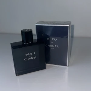 Bleu de Chanel parfym herr 100ml - Bleu de Chanel är en ikonisk herrparfym med en djupblå, stilren glasflaska och matchande förpackning. Doften är fräsch och maskulin, perfekt för dig som gillar exklusiva och moderna parfymer. Flaskan har en minimalistisk design med tydlig Chanel-logga på korken.