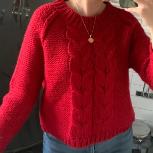 Röd stickad kabeltröja - Säljer en chunky röd stickad tröja med grovt kabelstickat mönster framtill. Helt oanvänd!