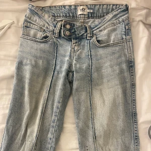 Ljusblå jeans med dubbla knappar 157 - Snygga ljusblå jeans från lager 157. Jeansen är low waist och bootcut. De har även en söm som är i mitten av varje ben. Säljs eftersom det är för korta. 