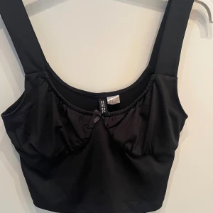 Svart gulligt linne - Svart croppad linne från H&M Divided med breda axelband och liten rosett framtill💕💕 Enbart provad!!