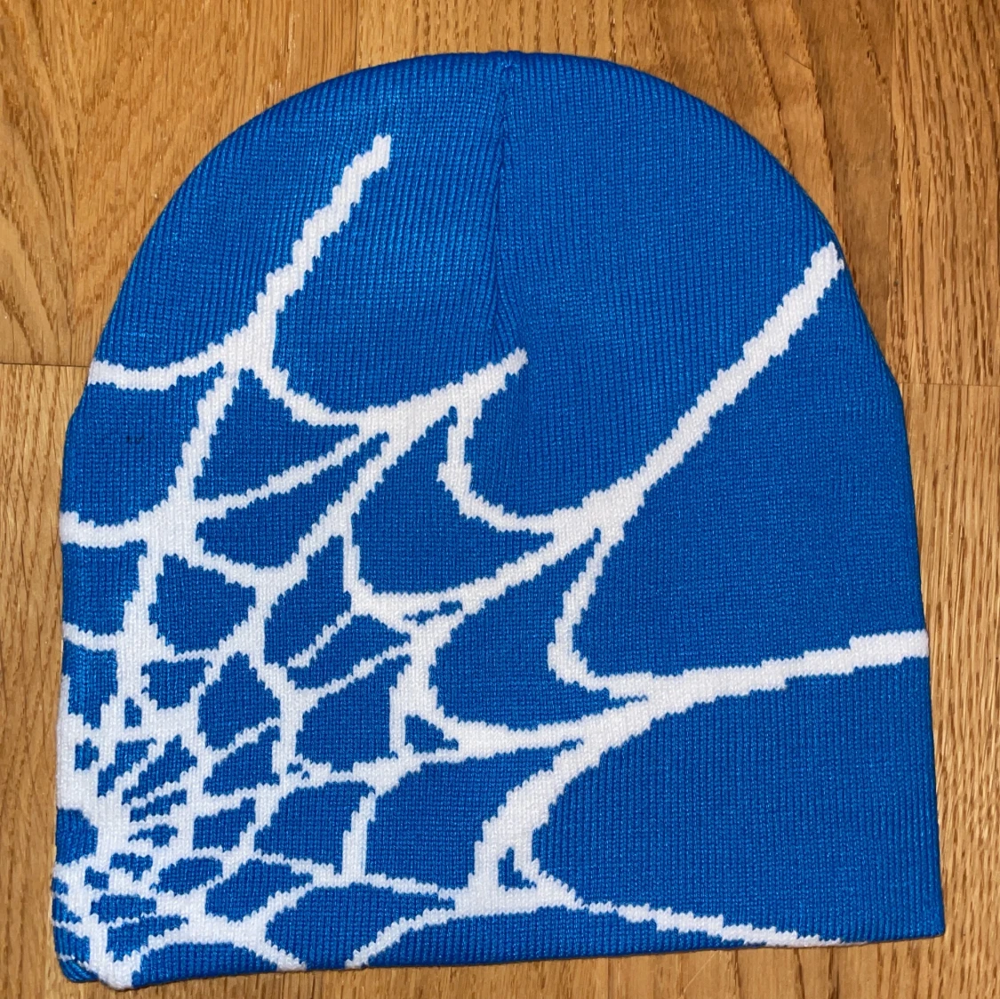 Blå mössa med vitt spindelnätsmönster