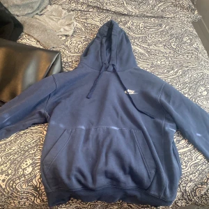 Blå hoodie från Nike med huva - Säljer en mörkblå hoodie från Nike i storlek S. Tröjan har huva med snörning, stor magficka och Nike-logga på bröstet. 