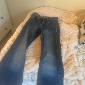 Blå bootcut jeans  - Säljer ett par klassiska blå jeans  i storlek. Jeansen är högmidjade men blir lågmidjade om man viker ner de.
