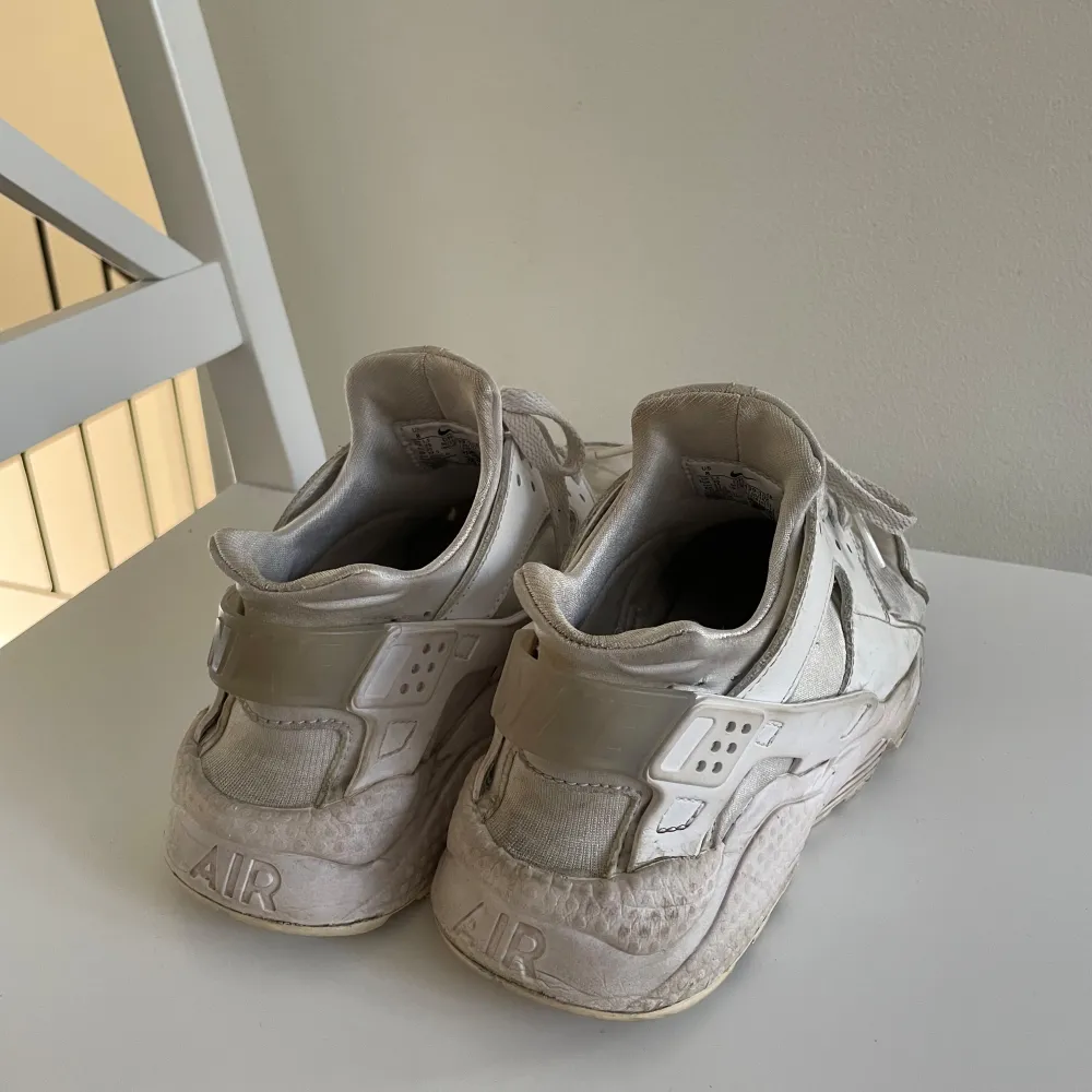 Säljer ett par vita Nike sneakers med snörning och rund tå. Skorna har en robust sula och är perfekta för en sportig look. De har en klassisk design med märkets logga på baksidan.. Kengät.