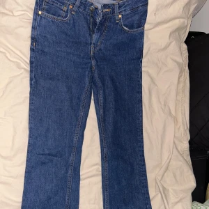 Blå jeansbyxor - Snygga blå jeansbyxor med klassisk femficksdesign och dragkedja. Perfekta för en avslappnad stil. De har en rak passform och är tillverkade i slitstarkt denim.