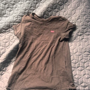 Svart t-shirt från Levi's - Säljer en svart t-shirt från Levi's med en liten röd logga på bröstet. Perfekt för en avslappnad stil. T-shirten är kortärmad och gjord i mjukt material. Suprbra skick. Storlek S. !!den är mörkare än vad den ser ut att vara på bilderna!!