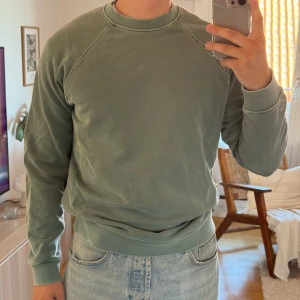 Grön sweatshirt från Samsoe & Samsoe - Säljer en stilren grön sweatshirt med rund hals och långa ärmar. Tröjan har ribbade muddar vid ärmslut och nederkant.