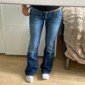 Blå bootcut jeans - Snygga blå bootcut jeans med låg midja och klassisk femficksdesign. 