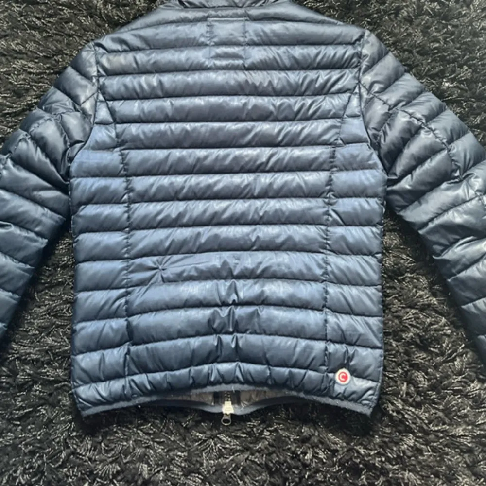 Säljer en snygg blå quiltad jacka från Colmar. Jackan har en dragkedja framtill och två praktiska fickor med dragkedjor. Perfekt för kyligare dagar med sin stilrena design och bekväma passform.. Takit.