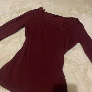 Vinröd långärmad topp från Gina Tricot - Säljer en stilren vinröd långärmad topp från Gina Tricot. Den är tillverkad i ett mjukt och bekvämt material.