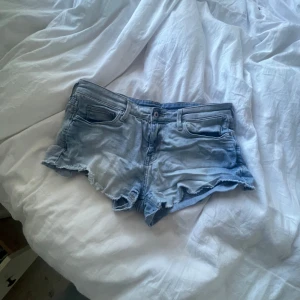 Ljusblå jeansshorts med fransar - Snygga ljusblå jeansshorts, köptes secondhand och är knappt använda av mig. 
