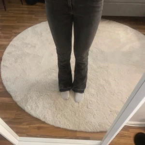 Svarta jeans med bootcut - Säljer ett par svarta jeans med bootcut-stil. De har en klassisk design med knapp och dragkedja framtill. Perfekta för en stilren look. Den är väldigt stretchiga därav passar många.