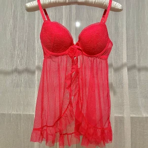 Röd negligé från H&M - Säljer en röd negligé från H&M med spetsdetaljer och volangkant. Den har justerbara axelband och en söt rosett framtill. STORLEK EU38 eller 75B som passar byst 90-92cm.