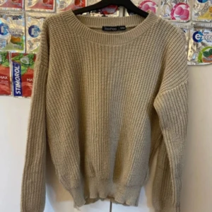 Beige stickad tröja från Boohoo - Säljer en beige stickad tröja från Boohoo i storlek S/M. Tröjan har en grovstickad struktur, rund halsringning och långa ärmar. Perfekt för lager-på-lager och chill höst- eller vinterstil. Enkel att matcha med jeans eller kjol.