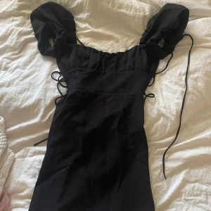 Svart kortklänning med puffärm från Zara - Supersnygg svart kortklänning från Zara med puffiga ärmar och snörning i midjan och ryggen. 