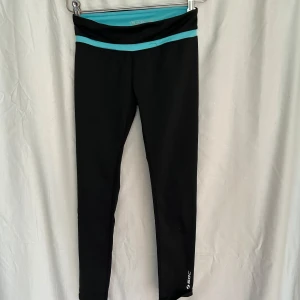 Svarta leggings från SOC med turkos detalj - Svarta leggings från SOC med turkos midjeband. Snygg, sportig look och stretchigt material som passar perfekt till träning eller chill. Långa ben och smal passform, med diskret logga vid benet. Riktigt bekväma och lätta att röra sig i.
